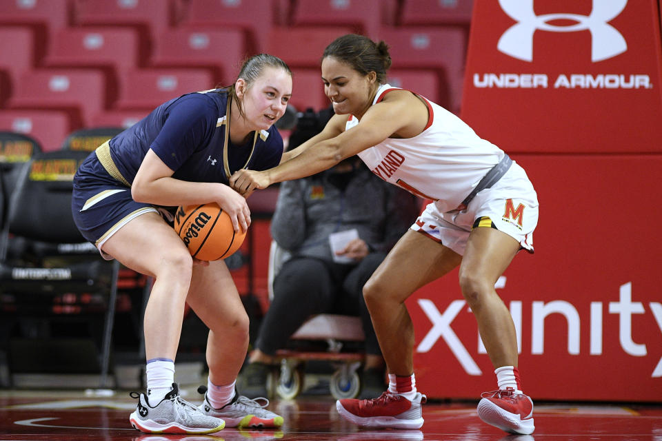 Maryland guard Katie Benzan, right, reaches for the ball held by Mount St. Mary's forward Isabella Hunt during the second half of an NCAA college basketball game Tuesday, Nov. 16, 2021, in College Park, Md. Maryland won 98-57. (AP Photo/Nick Wass)