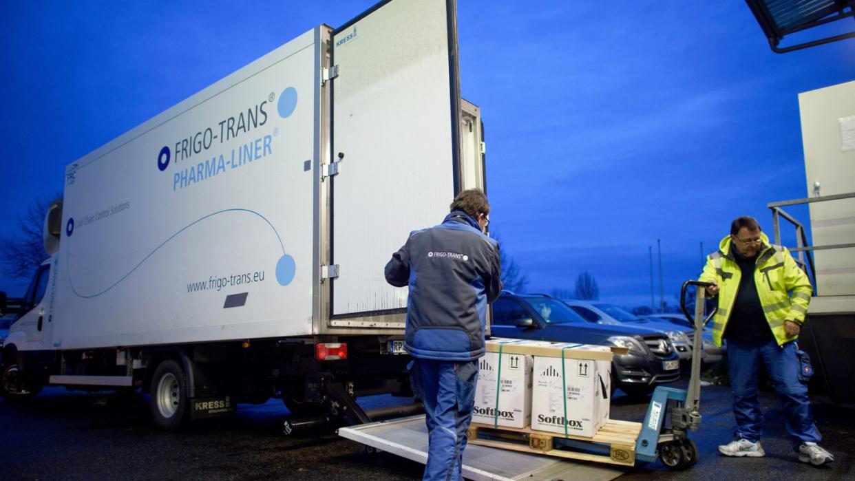 Entladung eines Kühllastwagens mit Impfdosen von Biontech/Pfizer in einem Logistikzentrum.