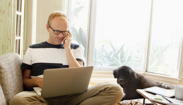 Caucasian man using laptop on sofa