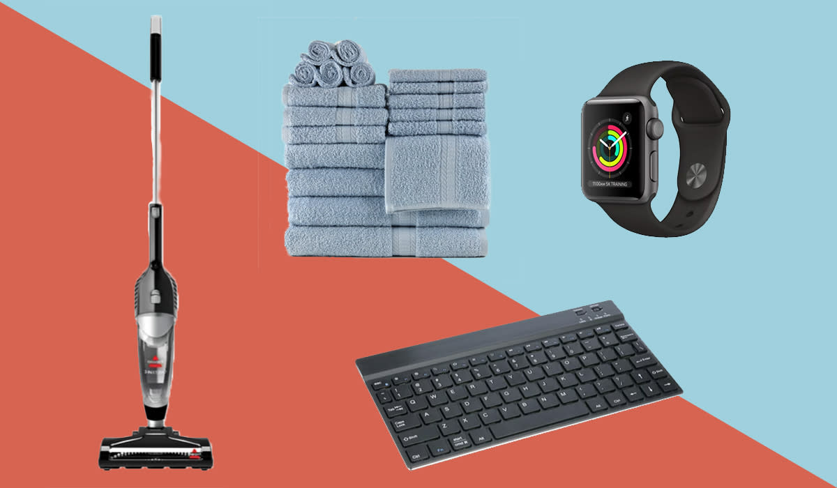 Stick vacuum, stack of towels, Apple watch and keyboard shown on dual-colored background