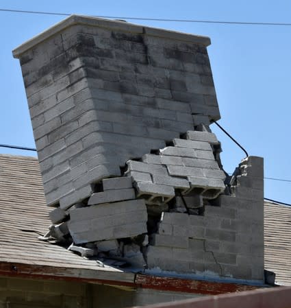 A damaged chimney remains on a roof after an earthquake near Trona