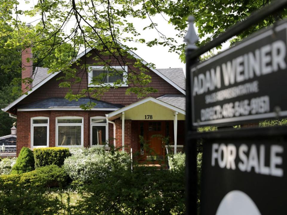 FILE PHOTO: A realtor's sign stands outside a house for sale in Toronto