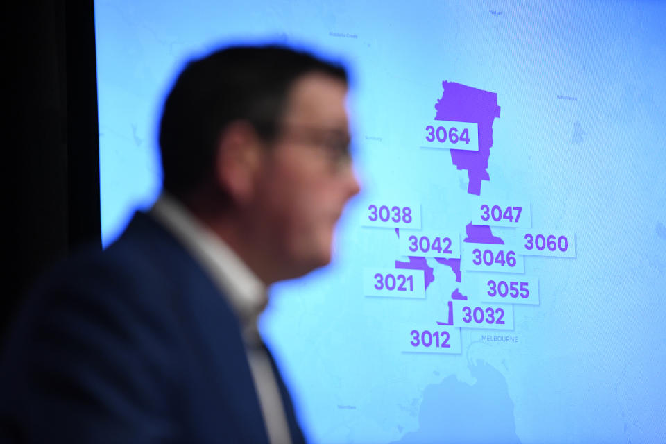 Postcodes of Melbourne suburbs are seen on a television screen as Victorian Premier Daniel Andrews speaks to media.