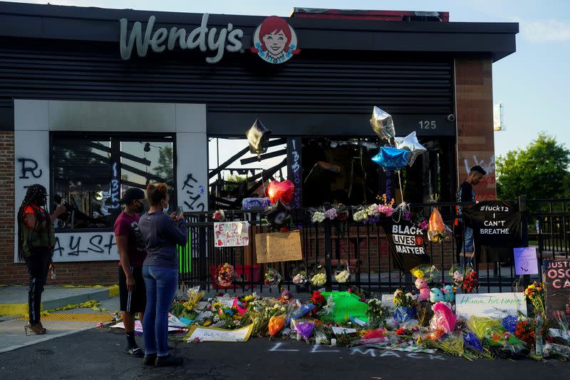 FILE PHOTO: People take photos of a memorial to Rayshard Brooks at the Wendy's where he was shot and killed by police officers, in Atlanta