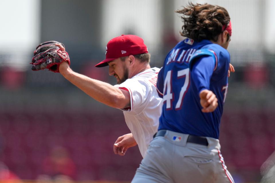 Cincinnati Reds starting pitcher Graham Ashcraft tags first to put out Texas Rangers shortstop Josh Smith, which got Ashcraft out of a bases-loaded jam.