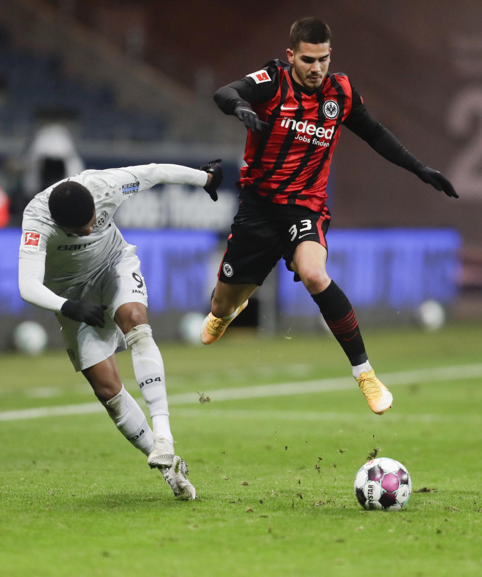 El jugador de Frankfurt Andre Silva, derecha, avanza con el balón ante la defensa de Leon Bailey, de Bayer Leverkusen, en un partido de la Bundesliga el sábado, 2 de enero del 2021. (AP Foto/Michael Probst)