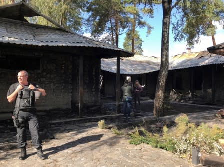 A law enforcement officer stands at a site of a burnt house, which is reportedly owned by former Governor of the Ukrainian Central Bank Valeria Gontareva, in Kiev