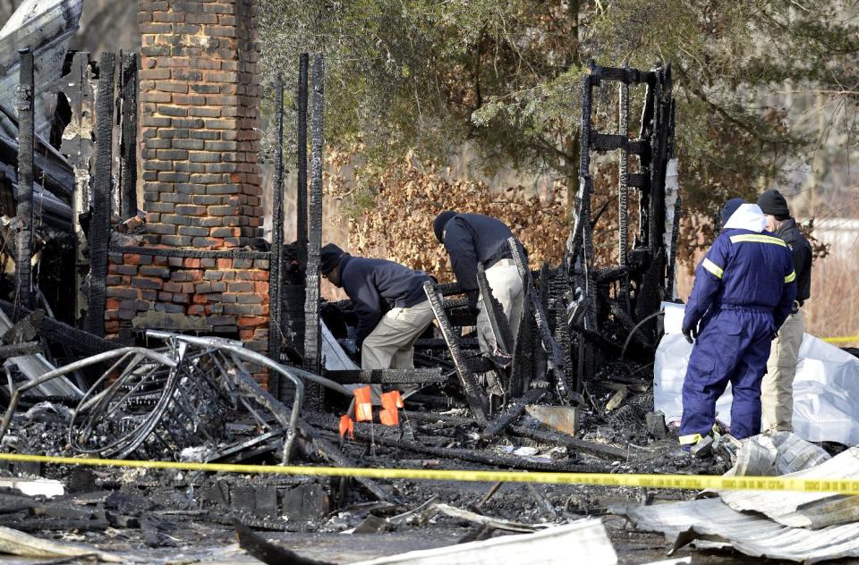 Kentucky State Fire investigators work at the scene of early morning house fire in Depoy, Ky. Thursday Jan. 30, 2014. As many as nine people were killed early Thursday in a house fire in rural western Kentucky and two people were taken to a hospital for treatment, officials said. Eleven people lived in the home in the Depoy community of Muhlenberg County, Greenville Assistant Fire Chief Roger Chandler said. (AP Photo/Timothy D. Easley)