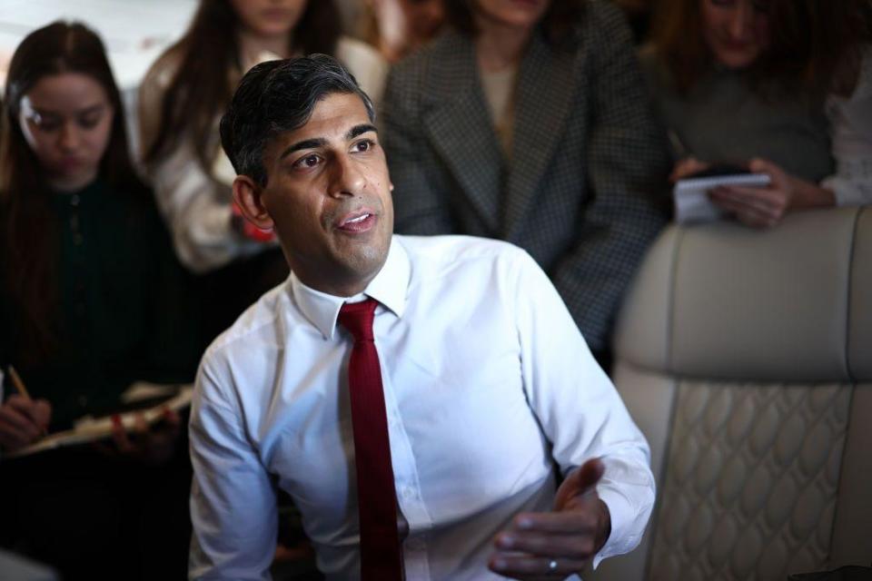 Rishi Sunak hablando con periodistas en su avión