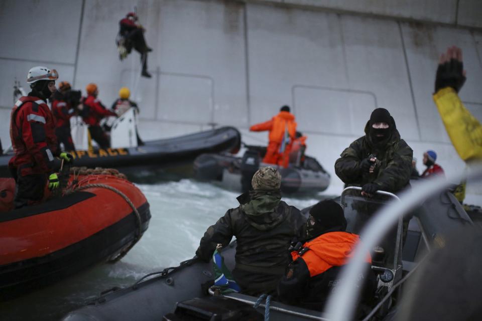 According to Greenpeace, a masked man identified as a Russian coast guard officer points a gun at a Greenpeace International activist, during a protest near a Gazprom oil platform in the Pechora Sea