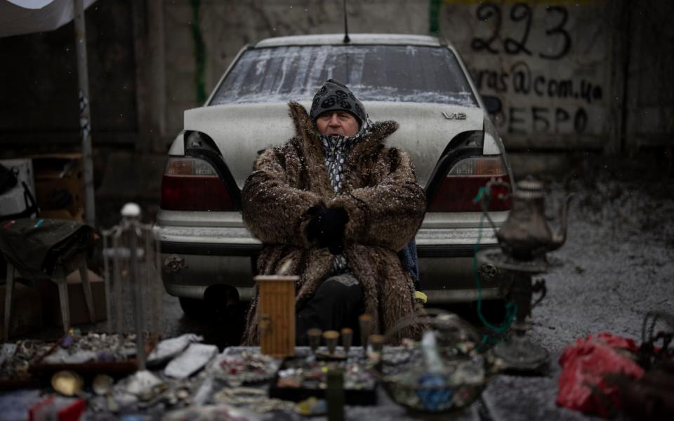 A vendor sits at a flea market in Kyiv - AP Photo/Daniel Cole