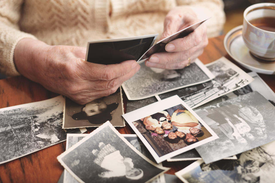 Woman looks at black and white photos on top of a table.