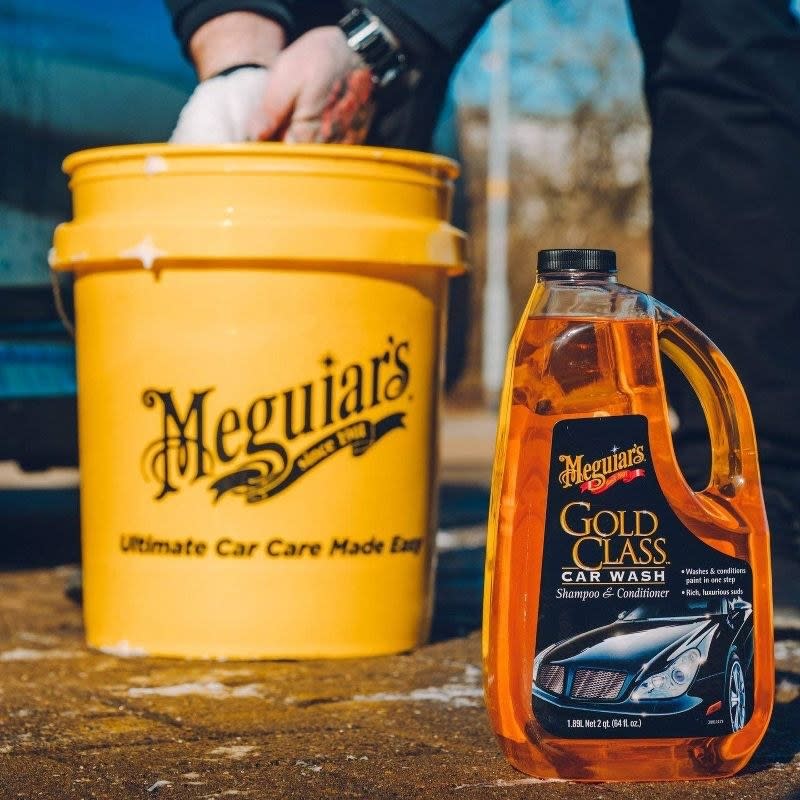 the yellow bottle of car wash next to a model using a large yellow bucket