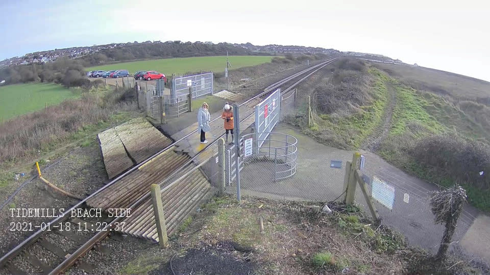 CCTV footage shows the women on the level crossing before they start taking photos. (SWNS)