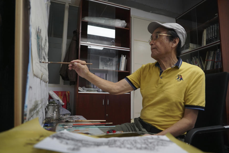 Zeng Fanzhi, a retired architect turned artist, paints at his studio in Shenzhen in southern China's Guangdong province, Tuesday, Oct. 24, 2023. Zeng painted stark, realist portrayals of life in China under zero-COVID, saying he did so to capture a unique moment in history. (AP Photo/Dake Kang)