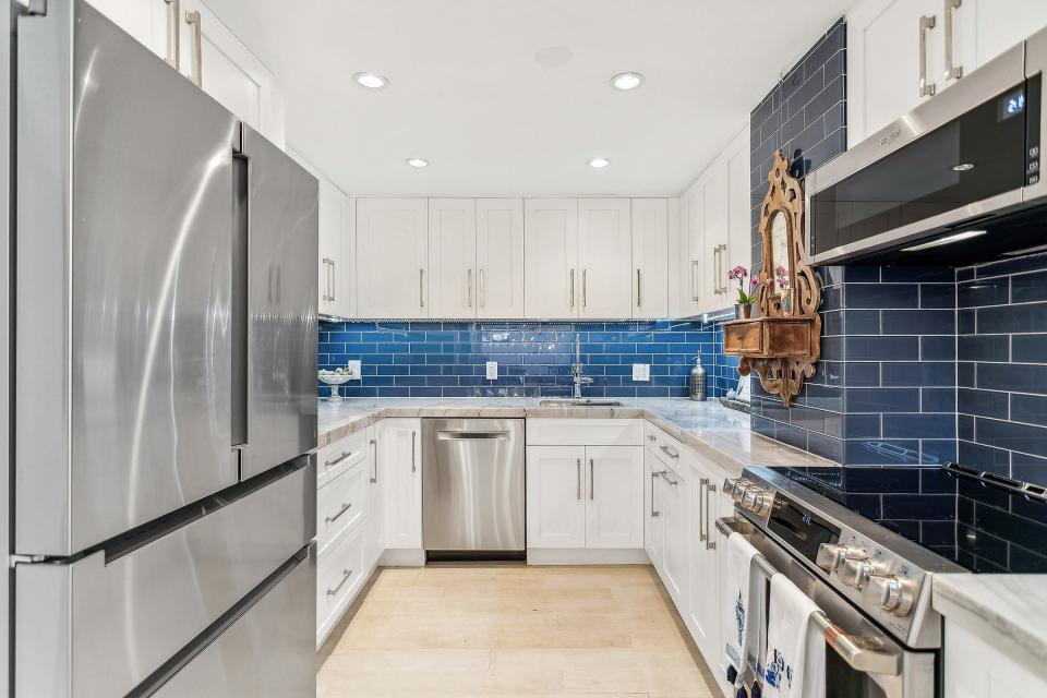 The U-shaped kitchen has stainless-steel appliances and a tiled backsplash.
