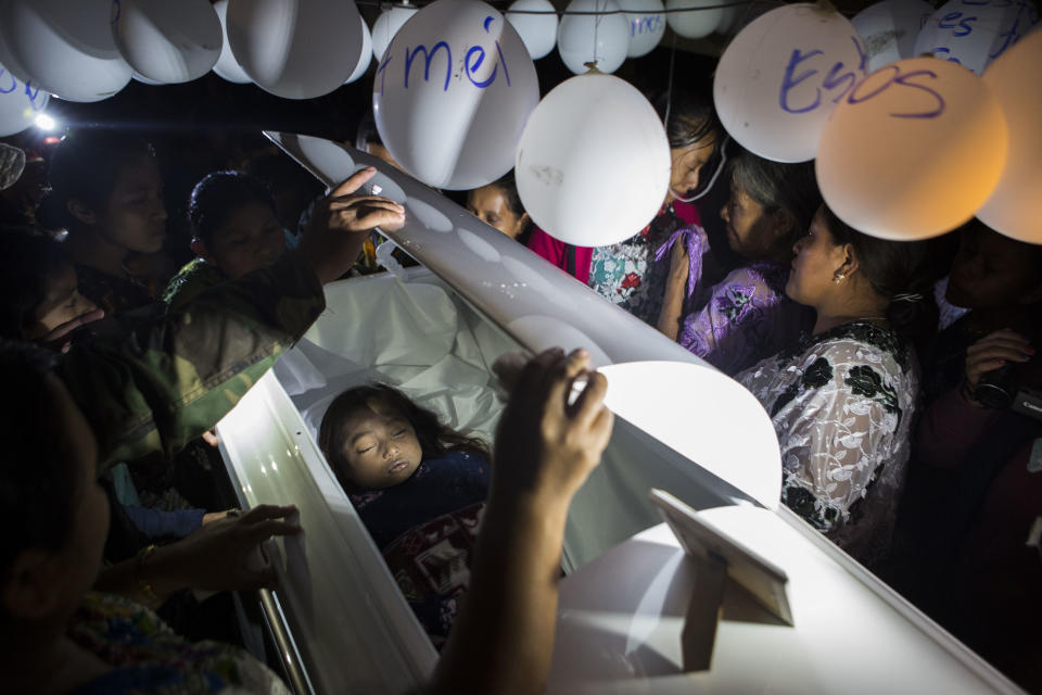 Family members pay their final respects to 7-year-old Jakelin Caal Maquin during a memorial service in her grandparent's home in San Antonio Secortez, Guatemala, on Monday, Dec. 24, 2018. The body of the 7-year-old girl who died while in the custody of the U.S. Border Patrol was handed over to family members in her native Guatemala on Monday for a last goodbye. (AP Photo/ Oliver de Ros)