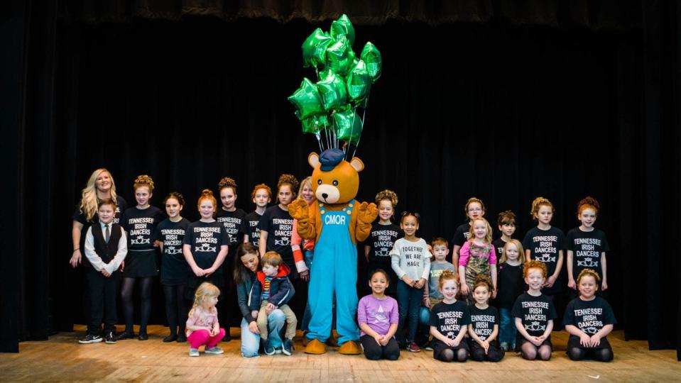 Charlie Bear, the Children's Museum mascot, joins the Tennessee Irish Dancers at a previous year's International Festival.