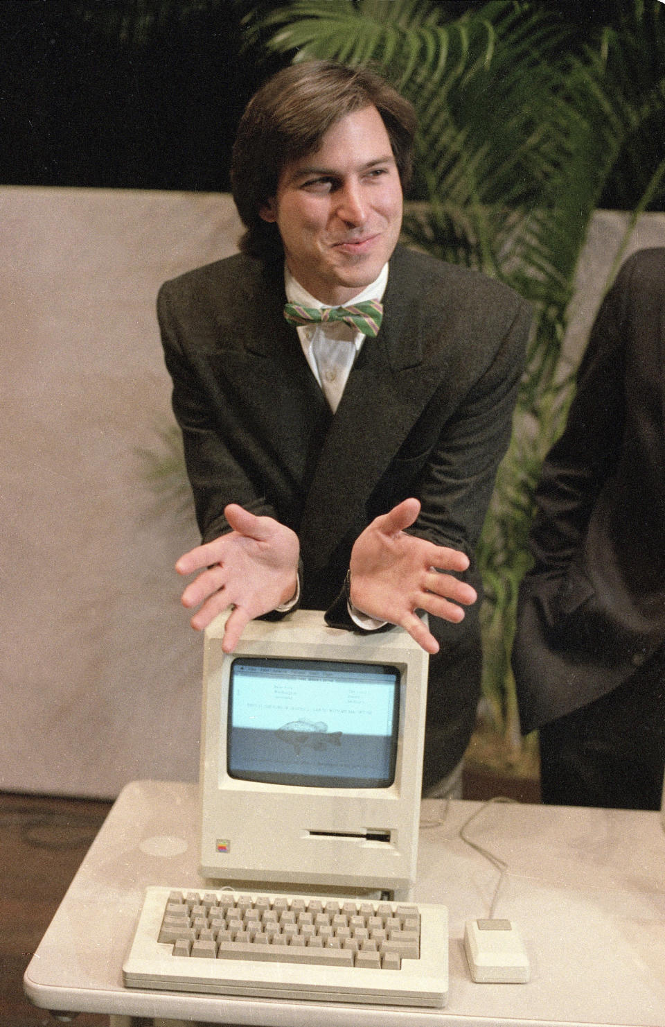 File - Steven Jobs, then chairman of the board of Apple Computer, leans on the new Macintosh personal computer following a shareholder's meeting Jan. 24, 1984 in Cupertino, Ca. The Macintosh computer lived up to the revolutionary promise made by Apple co-founder Jobs at it's 1984 unveiling. (AP Photo/Paul Sakuma, File)