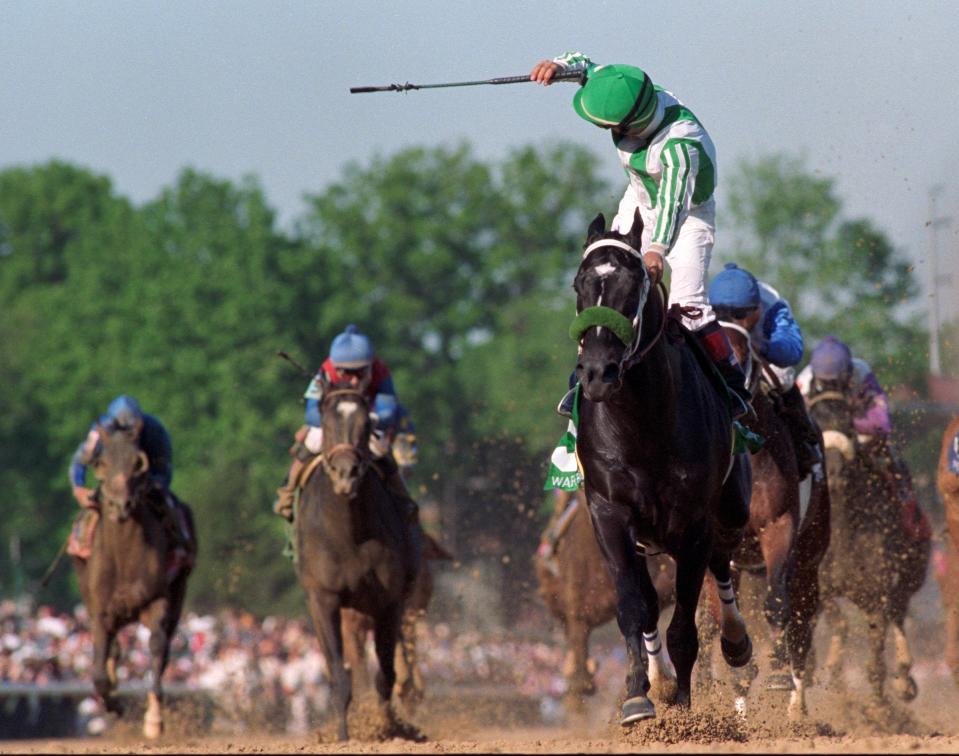 Jockey Victor Espinoza looks back to see his competitors as he crosses the finish line of the 2002 Kentucky Derby aboard War Emblem.