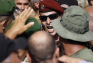 A Lebanese retired special forces soldier shouts slogans, as he tries with other protesters to enter the parliament building where lawmakers and ministers are discussing the draft 2019 state budget, in Beirut, Lebanon, Friday, July 19, 2019. The budget is aimed at averting a financial crisis in heavily indebted Lebanon. But it was met with criticism for failing to address structural problems. Instead, the budget mostly cuts public spending and raises taxes. (AP Photo/Hussein Malla)