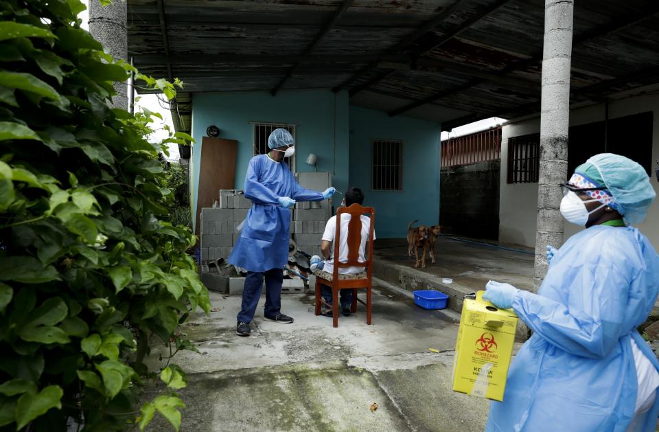 Un trabajador del Ministerio de Salud de Panamá toma una muestra a un residente mientras su equipo va de casa en casa para efectuar pruebas rápidas de COVID-19 el lunes 15 de junio de 2020, en el vecindario Nuevo Tocumen, en las afueras de la Ciudad de Panamá. (Foto AP/Arnulfo Franco)