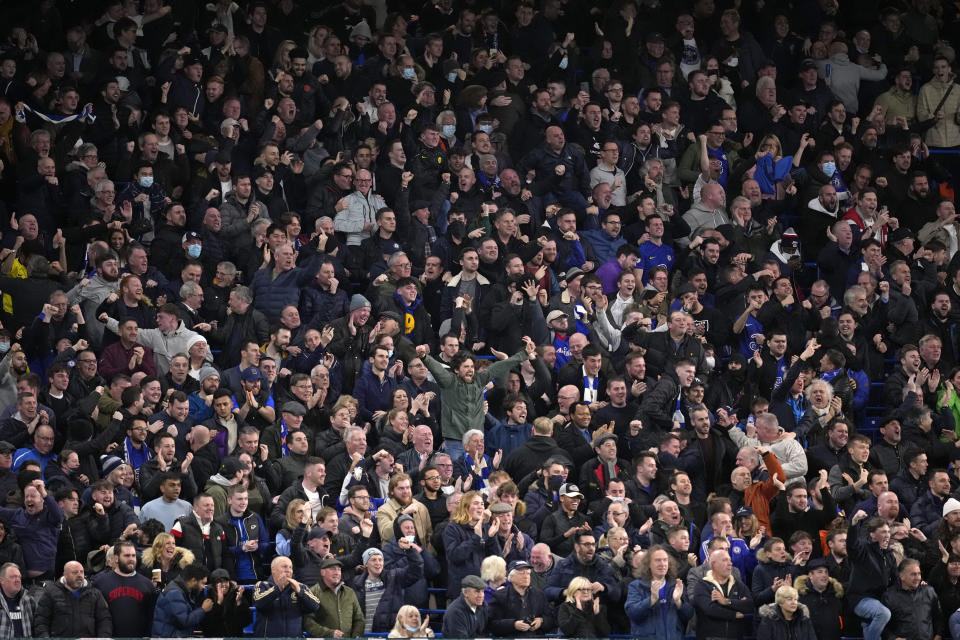 Chelsea supporters in the standing area of the ground celebrate during the English Premier League soccer match between Chelsea and Liverpool at Stamford Bridge in London, Sunday, Jan. 2, 2022. It is the first time standing sections have been allowed at Premier League stadiums since 1994. Chelsea is one of the clubs allowed by British authorities to take part in a pilot scheme that will allow some clubs to trial licensed standing areas from this month. (AP Photo/Matt Dunham)