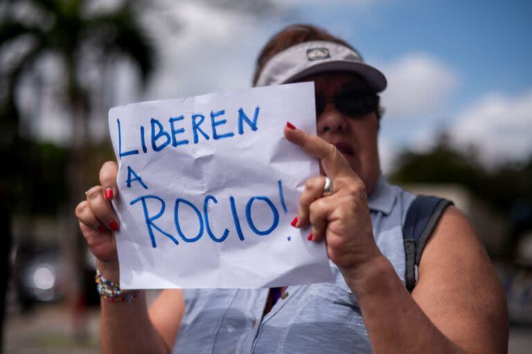 Una mujer sostiene un cartel que dice 