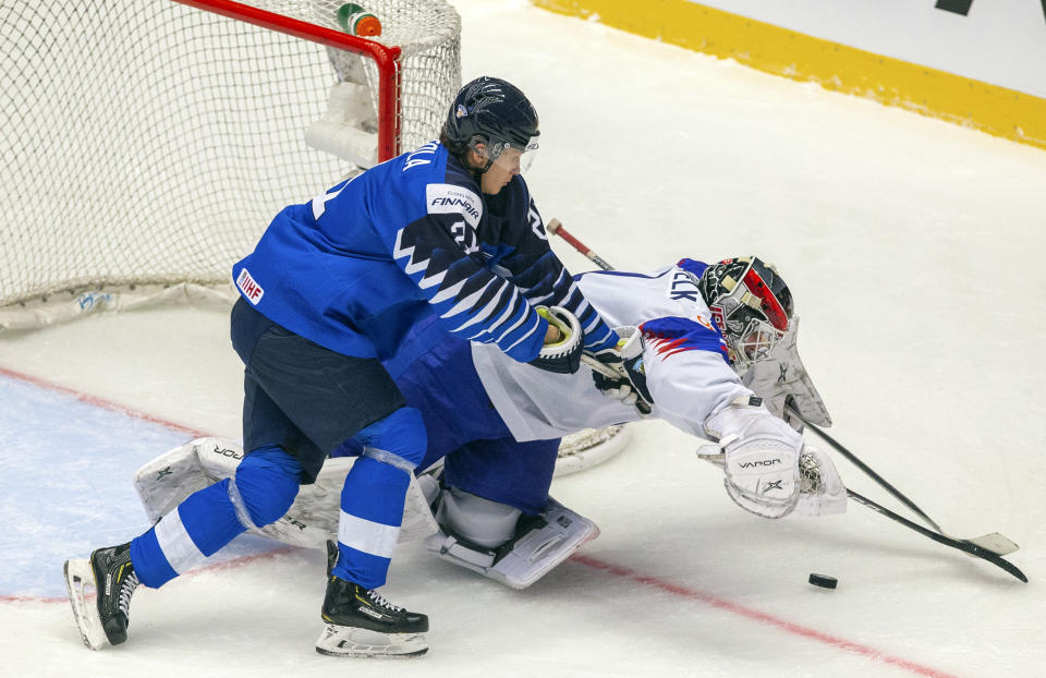 Finland's Patrik Puistola, left, and goaltender Slovakia's Samuel Vyletelka in action during the 2020 IIHF World Junior Ice Hockey Championships Group A match between Finland and Slovakia in Trinec, Czech Republic, Saturday Dec. 28, 2019. (Vladimir Prycek/CTK via AP)