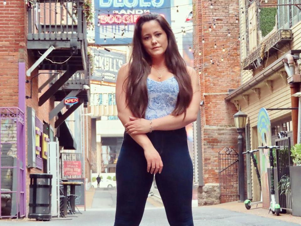 Jenelle Evans poses in a street wearing yoga pants