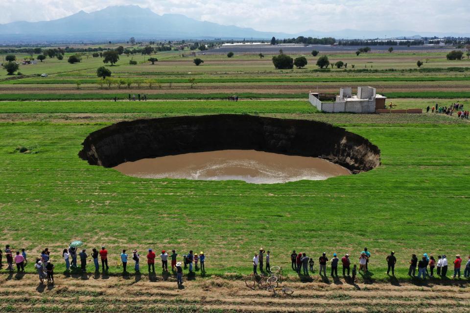 Locals have been coming to the site in large number to witness the expanding sinkhole (AFP via Getty Images)