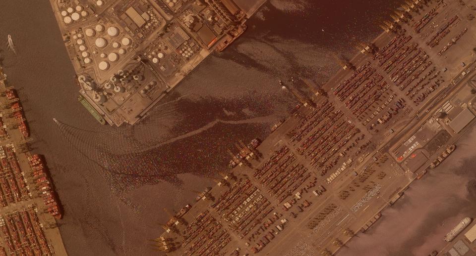 In this satellite photo shot by Planet Labs Inc., the Jebel Ali Port is seen Thursday, July 8, 2021, in Dubai, United Arab Emirates. A fiery explosion erupted on a container ship anchored in Dubai at one of the world's largest ports late Wednesday, July 7, authorities said, sending tremors across the commercial hub of the United Arab Emirates. A ship is seen in the photo spraying water on the stricken vessel. (Planet Labs Inc. via AP)