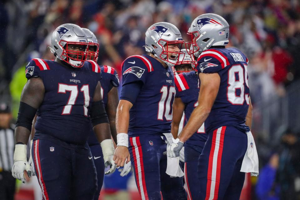 New England Patriots offensive guard Mike Onwenu (71) and quarterback Mac Jones (10) and tight end Hunter Henry (85) celebrate a touchdown against the Tampa Bay Buccaneers during the second quarter at Gillette Stadium in Foxboro on Sunday, Oct. 3, 2021.