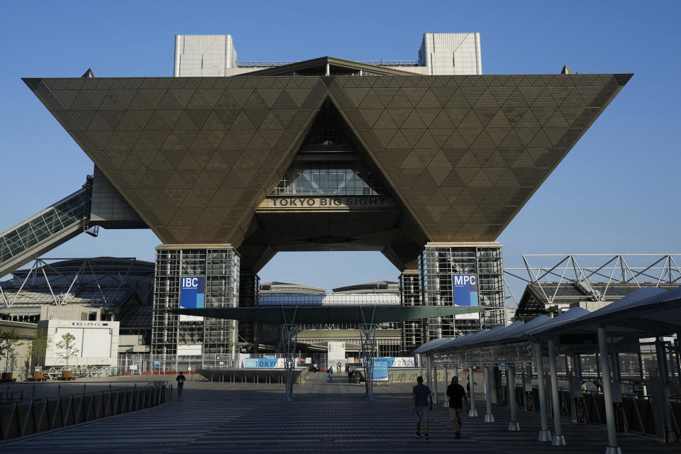 People walk outside the Tokyo Big Sight that houses the International Broadcast Center and Main Press Center in Tokyo, Monday, July 19, 2021. (AP Photo/Natacha Pisarenko)