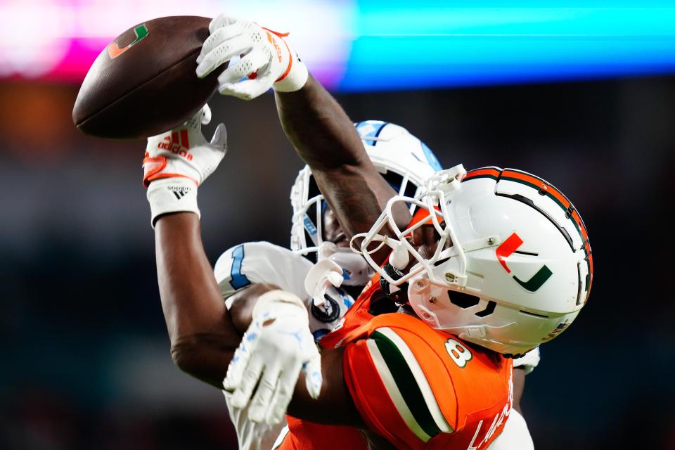 Oct 8, 2022; Miami Gardens, Florida, USA; North Carolina Tar Heels defensive back Tony Grimes (1) pressures Miami Hurricanes wide receiver Frank Ladson Jr. (8) as he attempts a catch during the second half at Hard Rock Stadium. Mandatory Credit: Rich Storry-USA TODAY Sports