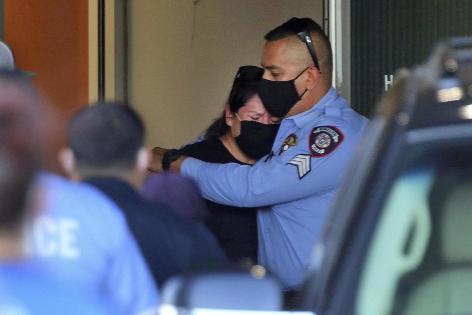 An officer consoles a mourner after the death of two McAllen police officers (The Monitor via AP)