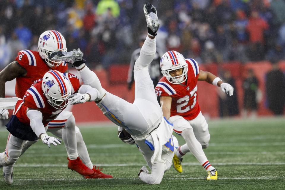 Chargers wide receiver Keenan Allen (13) is flipped by the Patriots defense after making a reception.