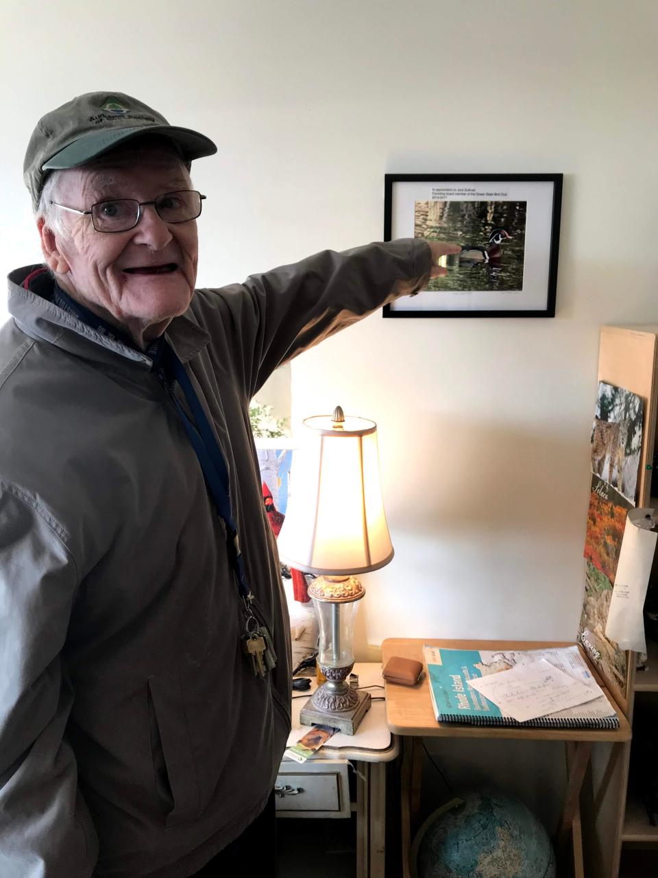 John "Jack" Sullivan, an avid birder, points to an award that the Ocean State Bird Club gave him upon his retirement from the organization's board.