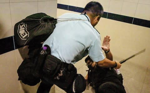 A policeman beats a protester in the men's toilet inside Hong Kong International Airport - Credit: Chris McGrath/Getty Images