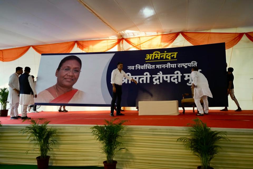 Workers in New Delhi put up a giant banner of Droupadi Murmu before results were announced (AP)