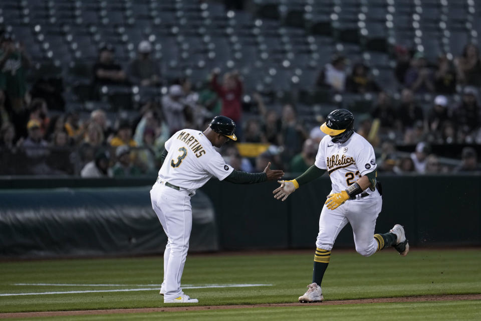 Oakland Athletics' Shea Langeliers, right, celebrates with third base coach Eric Martins, left, after hitting a solo home run against the San Diego Padres during the second inning of a baseball game Friday, Sept. 15, 2023, in Oakland, Calif. (AP Photo/Godofredo A. Vásquez)
