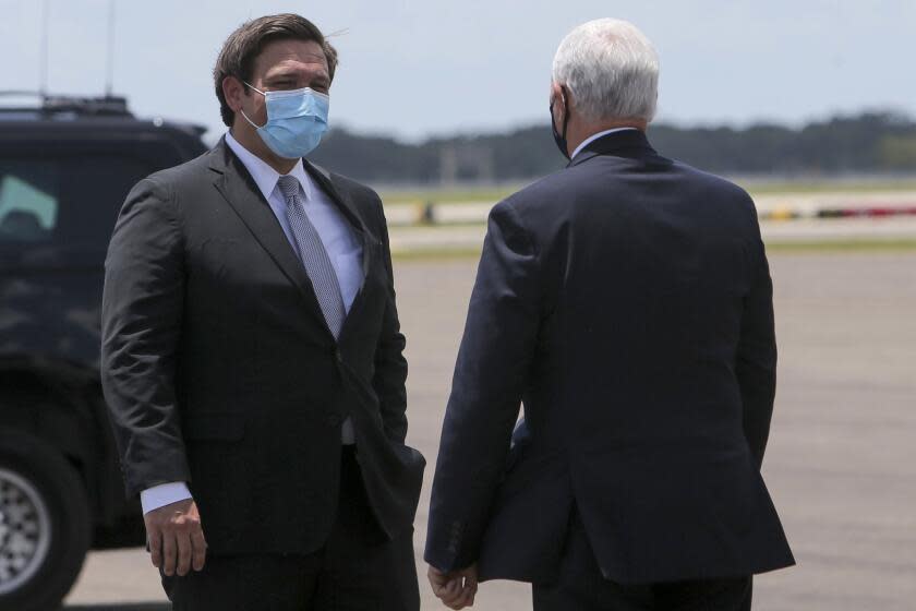 Florida Gov. Ron DeSantis greets Vice President Mike Pence upon his arrival at Tampa International Airport on Thursday, July 2, 2020, in Tampa. The Vice President met with Governor DeSantis regarding the efforts the state is making to combat COVID-19. (Ivy Ceballo/Tampa Bay Times via AP)