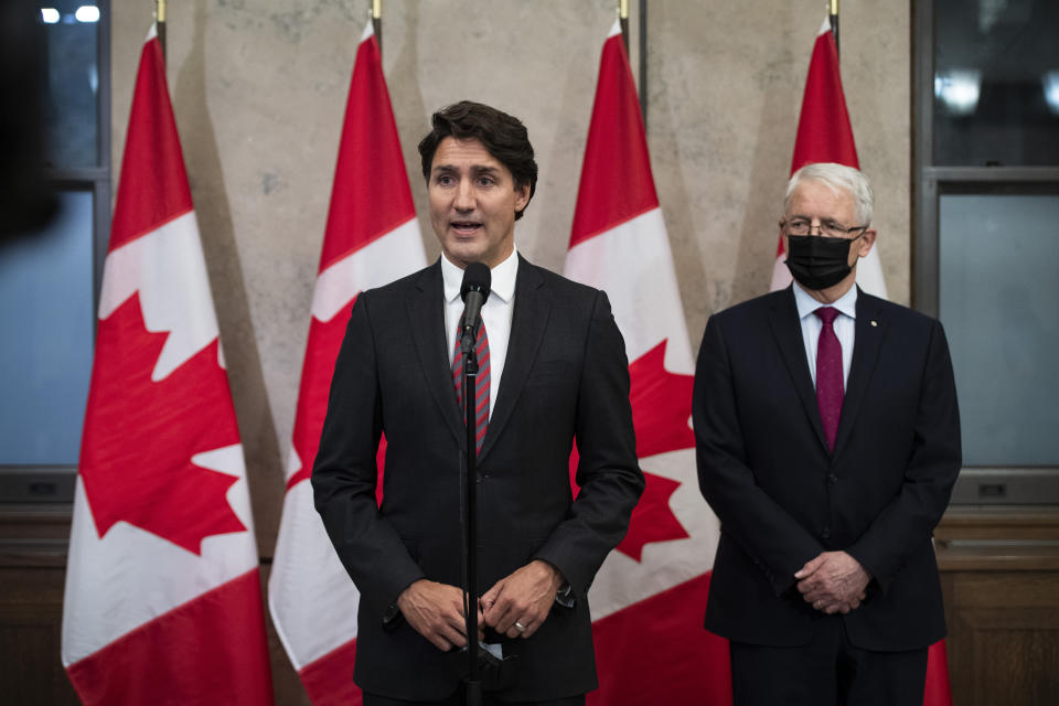 Prime Minister Justin Trudeau stands with Minister of Foreign Affairs Marc Garneau to announce that Canadians Michael Spavor and Michael Kovrig have been released from detention in China, on Parliament Hill in Ottawa, on Friday, Sept. 24, 2021. (Justin Tang/The Canadian Press via AP)