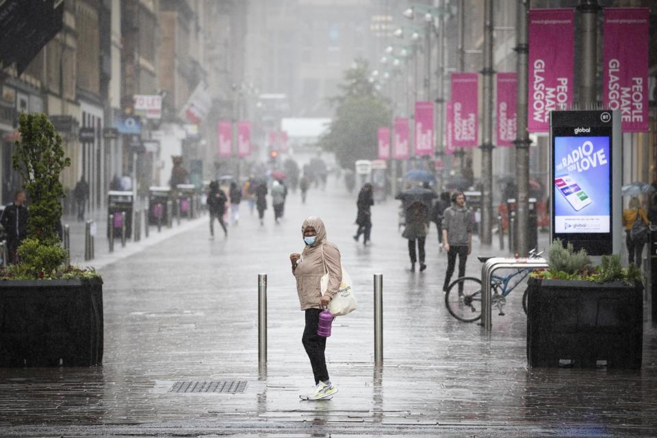 A file picture of a member of the public caught in heavy rain in Glasgow city centre: PA