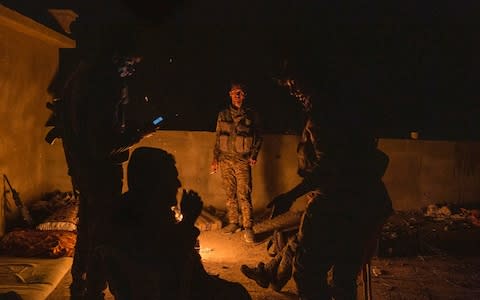 Soldiers rest on a rooftop as Syrian Democratic Forces resume their offensive in Baghuz, Syria - Credit: Sam Tarling