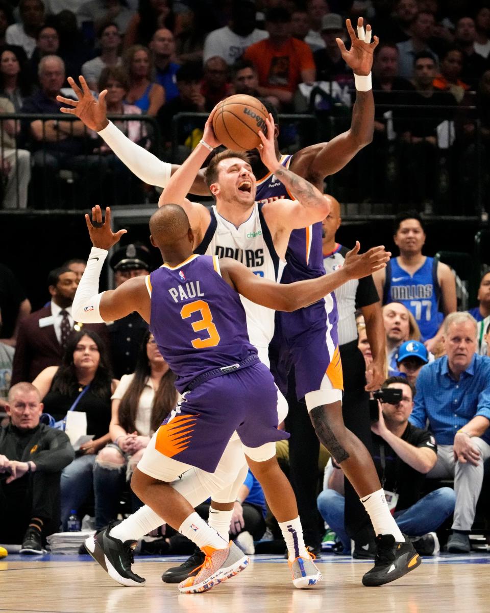 Dallas Mavericks guard Luka Doncic (77) is double teamed by Phoenix Suns guard Chris Paul (3) and center Deandre Ayton (22) during game three of the second round for the 2022 NBA playoffs at American Airlines Center.