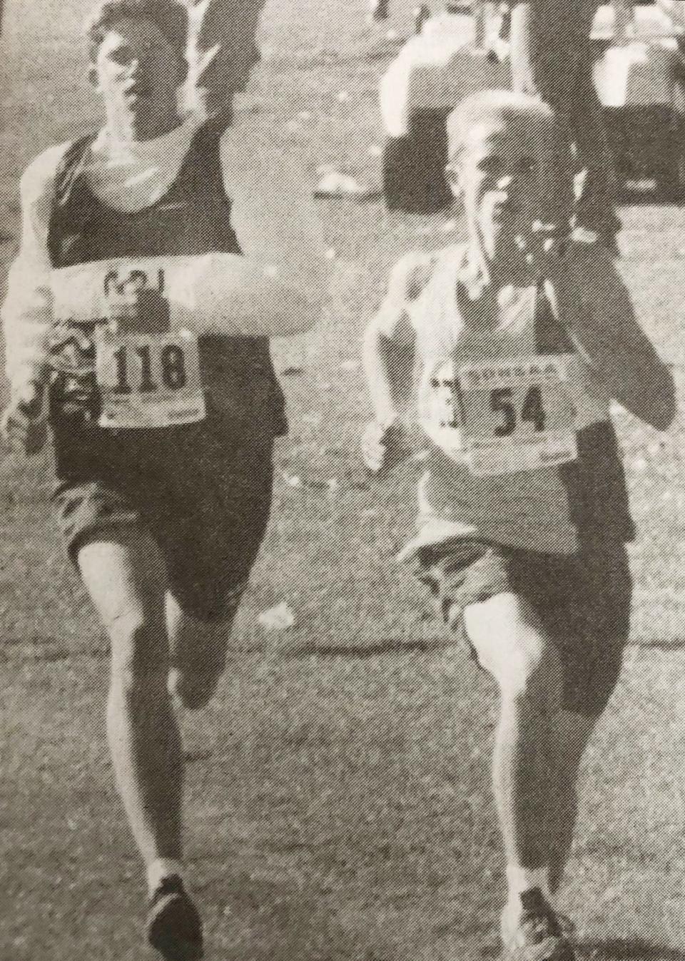 Jesse Knutson of Deubrook (right) holds off Great Plains Lutheran's Nathan Livingston to help the Dolphins repeat as the Class B boys division champions in the 1999 state Class B cross country meet at Huron.
