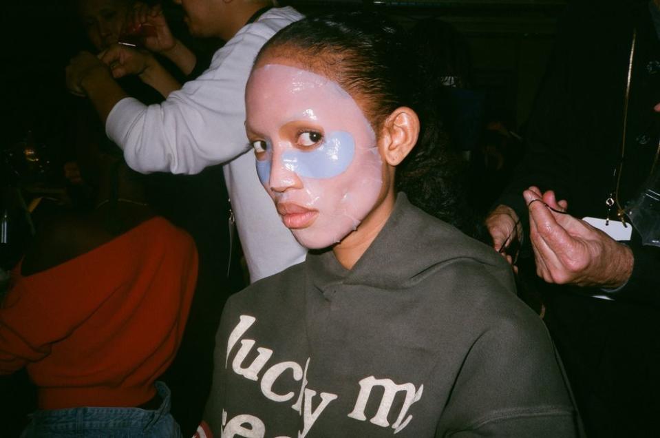 Since Aighewi has already had two different makeup looks today, the makeup team for the Brandon Maxwell Fall/Winter 2019 show put on a face mask to help her skin before applying a new look.