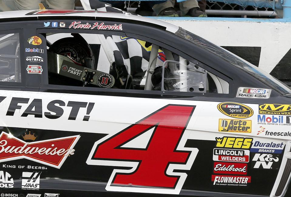 Kevin Harvick takes the checkered flag after winning the NASCAR Sprint Cup Series auto race Sunday, March 2, 2014, in Avondale, Ariz. (AP Photo/Ross D. Franklin)