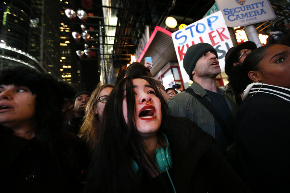 A woman weeps and cries out as police make arrests after protesters rallying against a grand jury's decision not to indict the police officer involved in the death of Eric Garner attempted to block traffic at the intersection of 42nd Street and Seventh Avenue near Times Square, Thursday, Dec. 4, 2014, in New York. (AP Photo/Jason DeCrow)